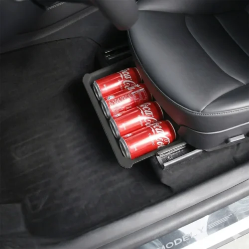 Under-seat storage tray filled with four Coca-Cola cans inside a car interior