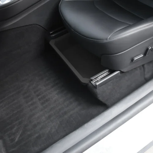 Retractable storage drawer under the front seat in a black car interior.