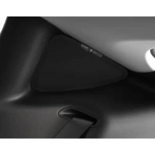 Close-up of a car interior showing a seat belt buckle and a triangular plastic panel.