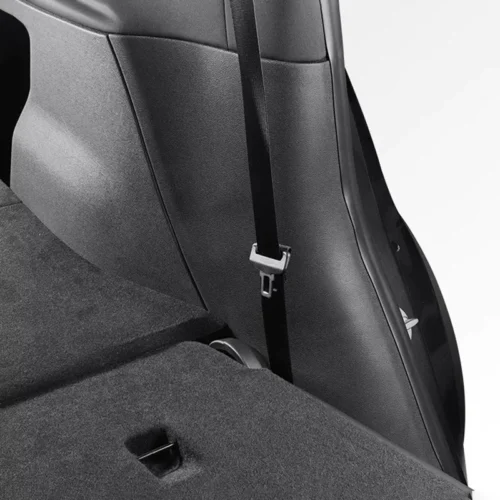 Close-up of a car interior showing a seat belt hanging over the back seat with buckle visible.