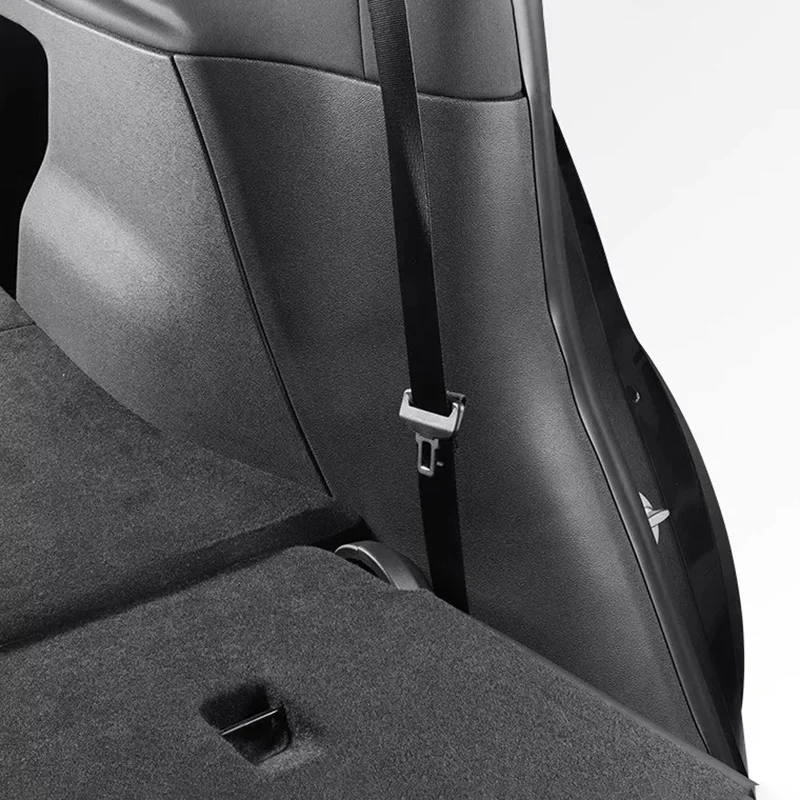 Close-up of a car interior showing a seat belt hanging over the back seat with buckle visible.