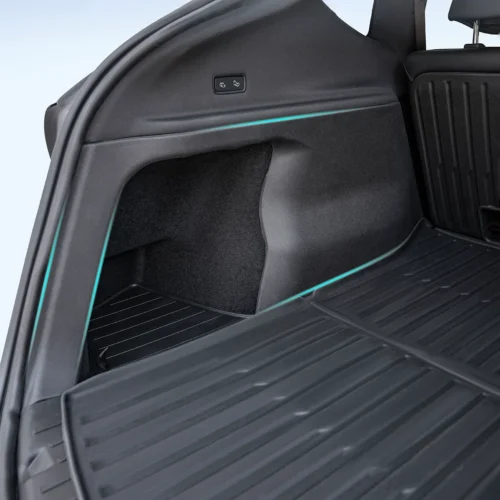 Open rear cargo area of a SUV, showing a left-side storage panel and teal accent trim along the trim edge.