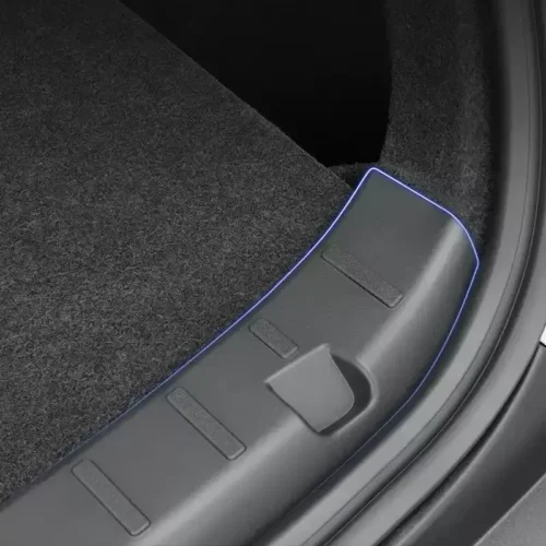 Close-up of a car door sill with blue LED edge lighting along the plastic trim and carpet.