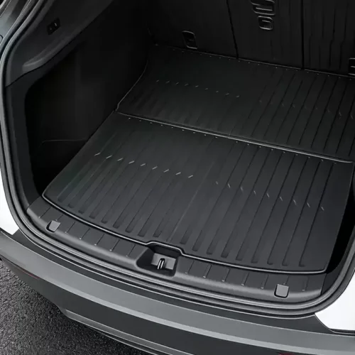 Car trunk with a textured rubber cargo mat extending into the rear seating area.