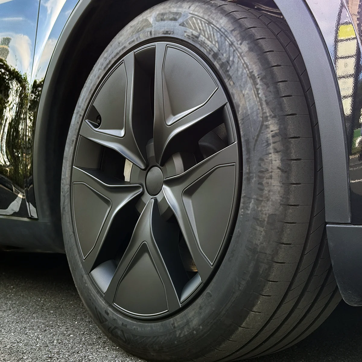 Close-up of a car wheel with a large matte gray alloy rim and low-profile tire.